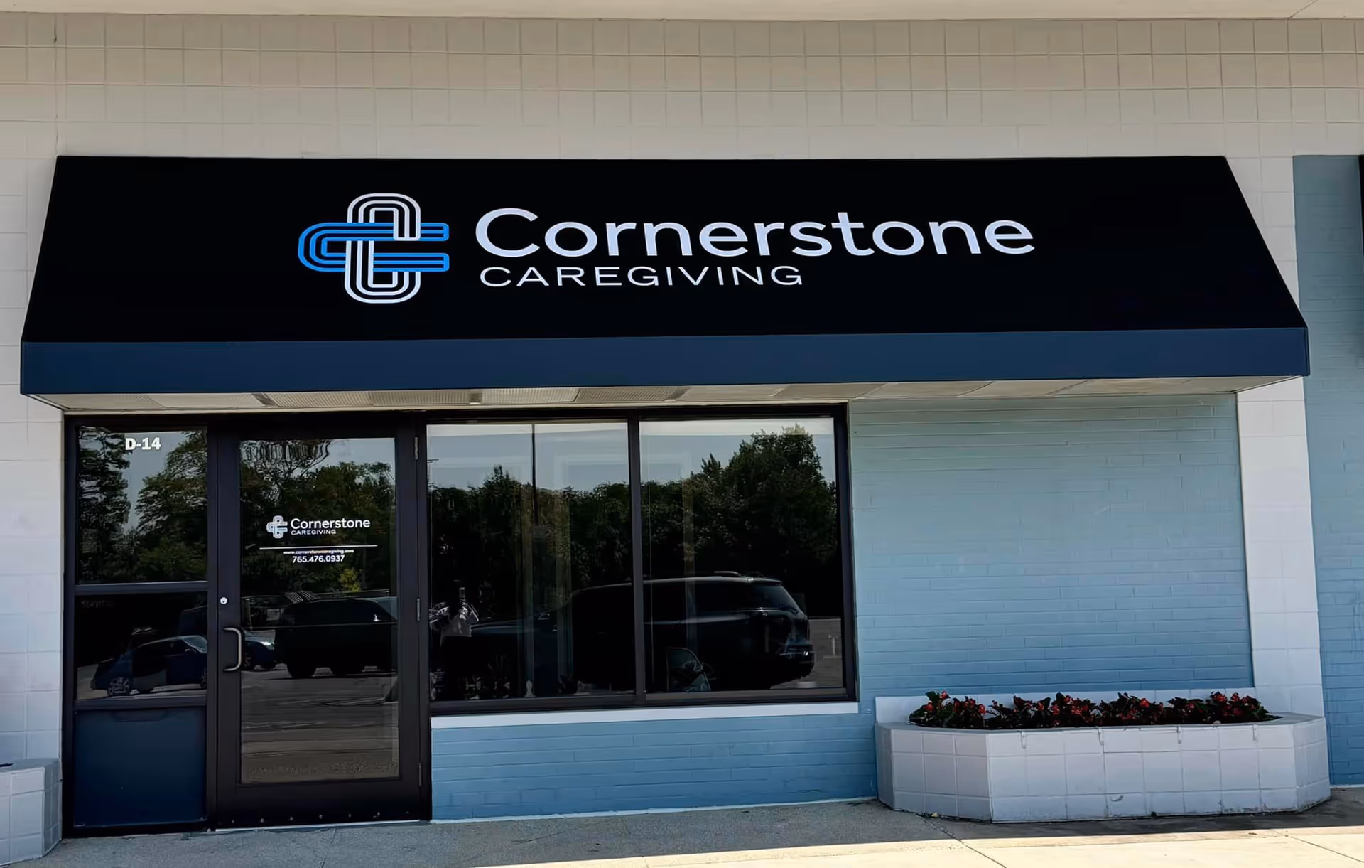 Front view of Cornerstone Caregiving storefront with a dark awning and glass entry.