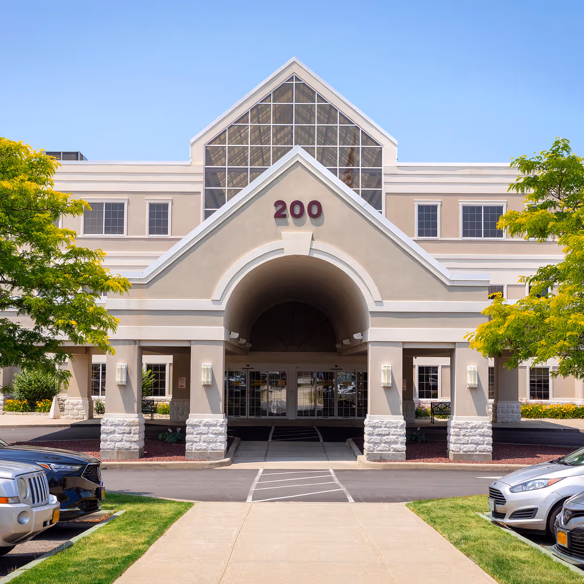 Exterior view of a senior rehab facility with a large arched entrance and a 200 sign.