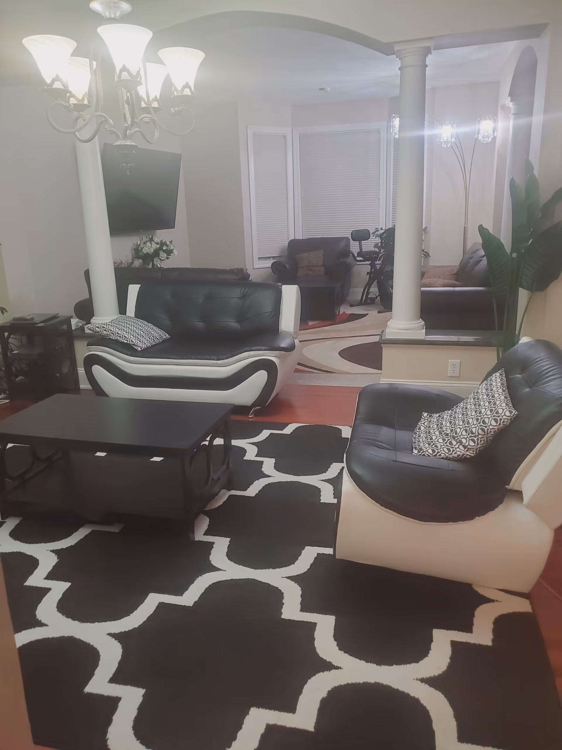 Cozy living room in a senior facility with black and white seating and a coffee table.