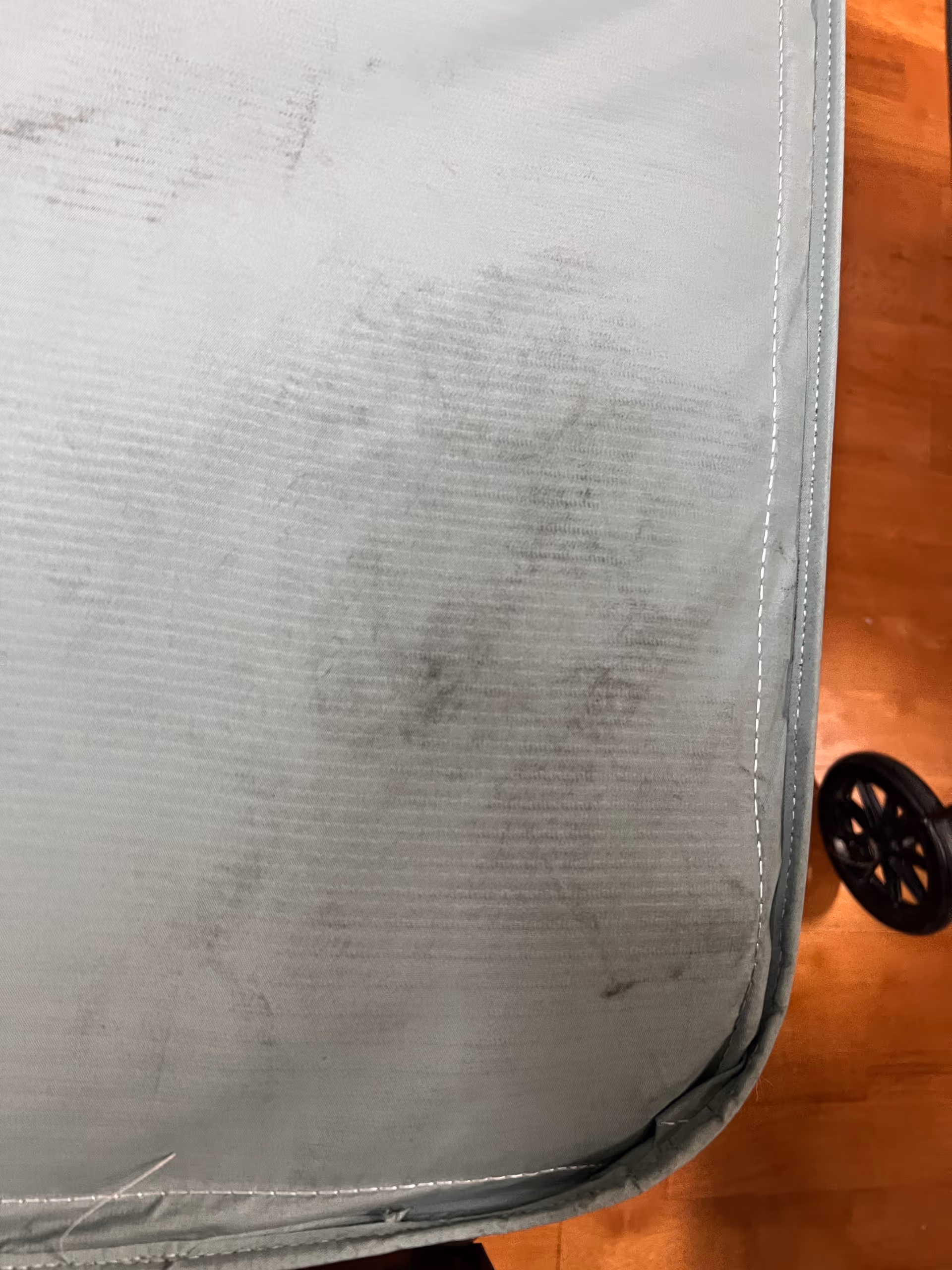Close-up of a light blue padded surface with visible dirt marks.