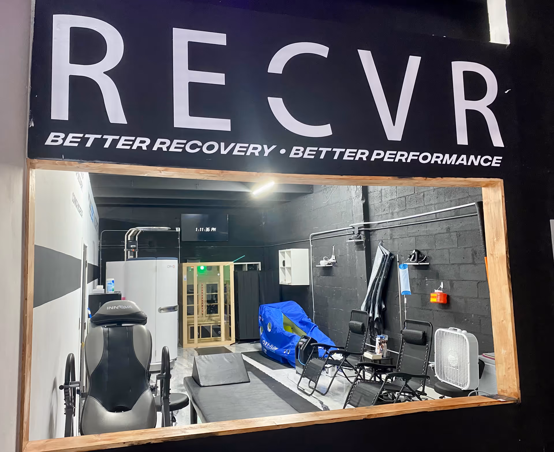 A gym-like rehab room with equipment inside a facility named RECVR.