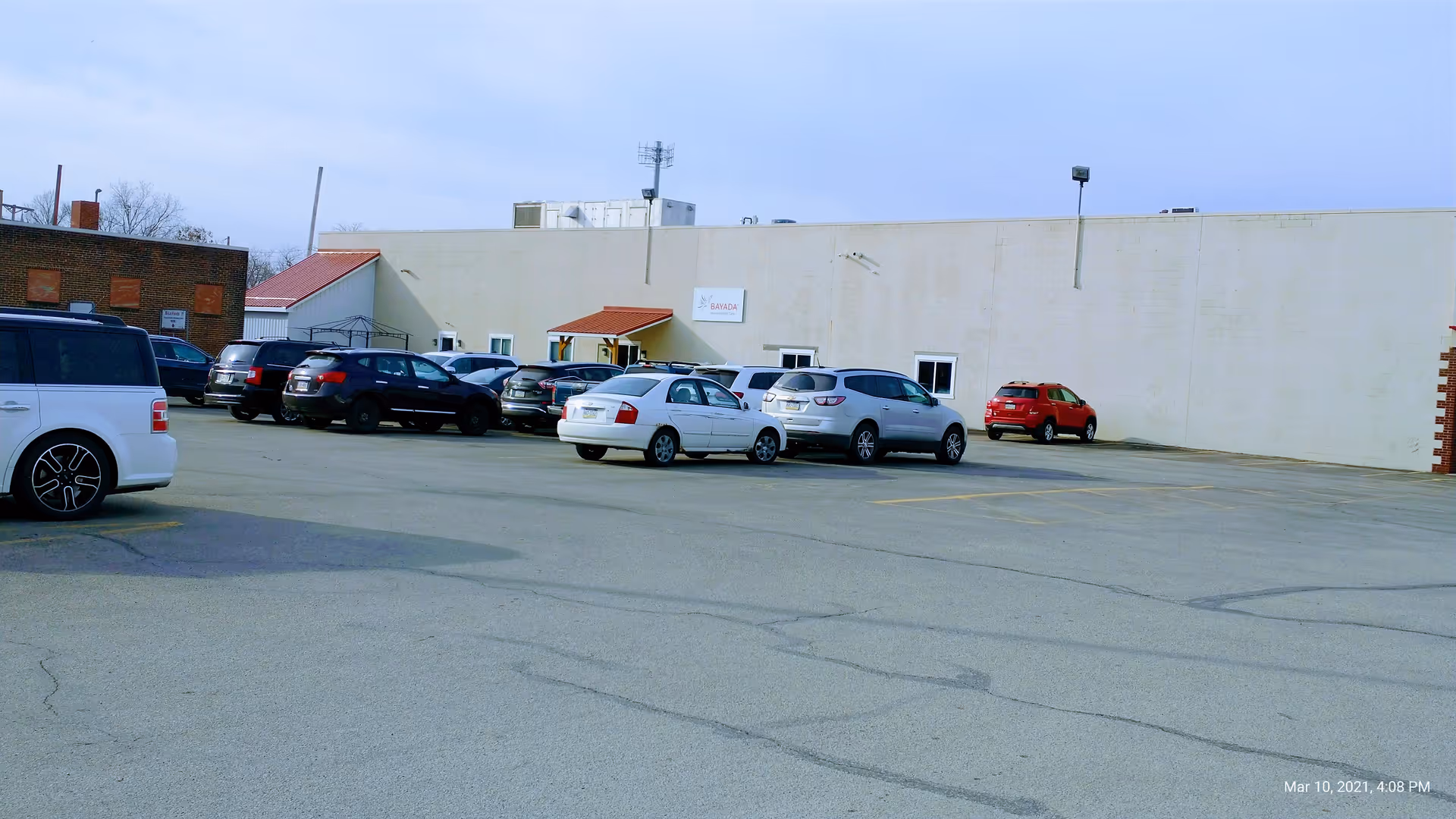 Parking lot in front of a large Bayada Pediatrics building with several parked cars.