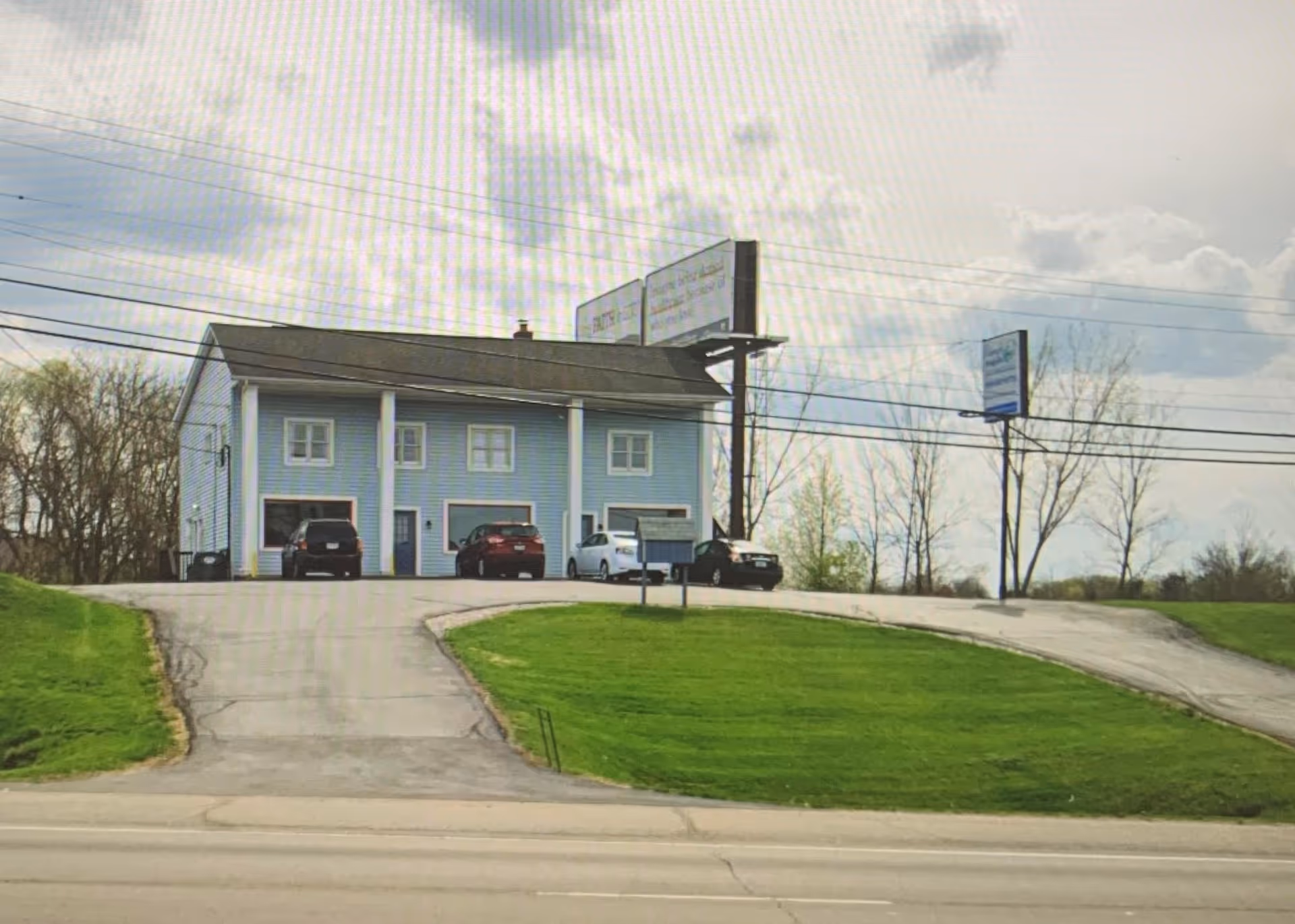 Blue two-story Visiting Angels senior home care building with parking and a sign