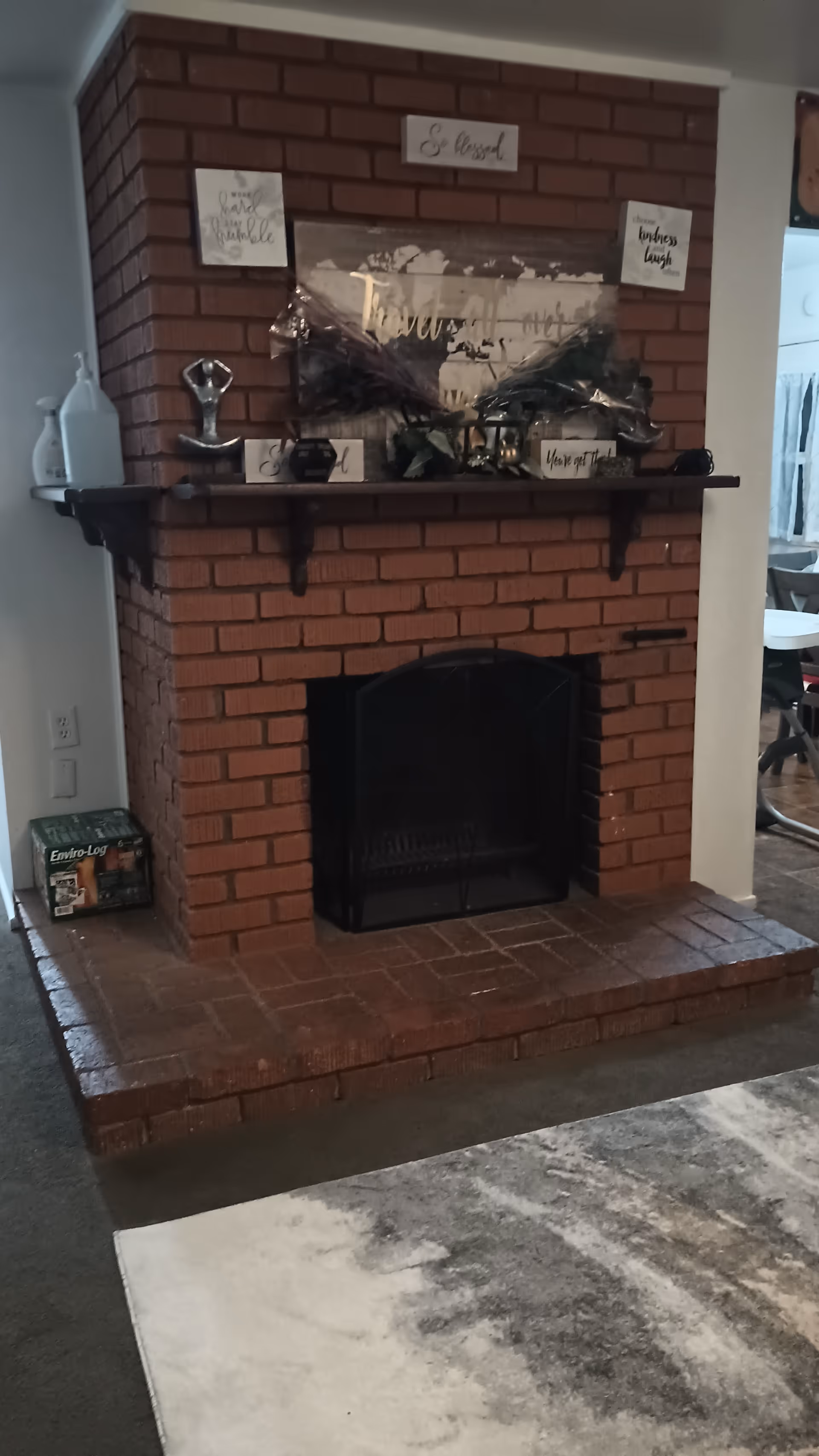 Brick fireplace with mantel and decorative items in a cozy living room