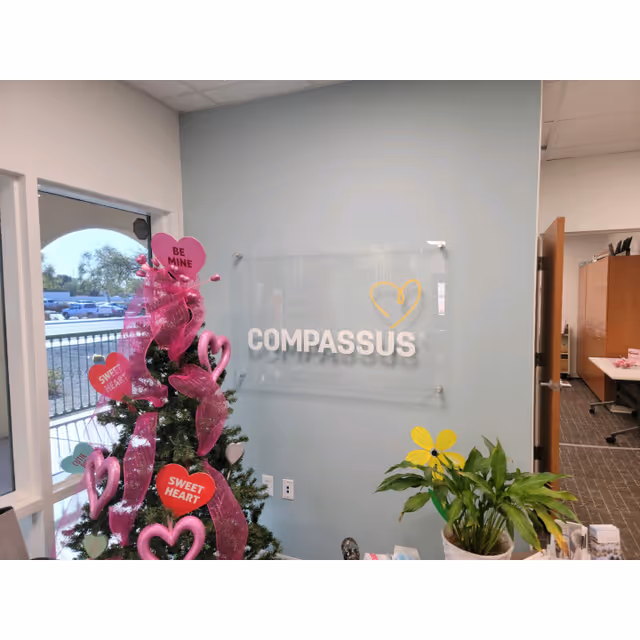 Interior view of Compassus reception area with glass sign and festive Christmas tree.