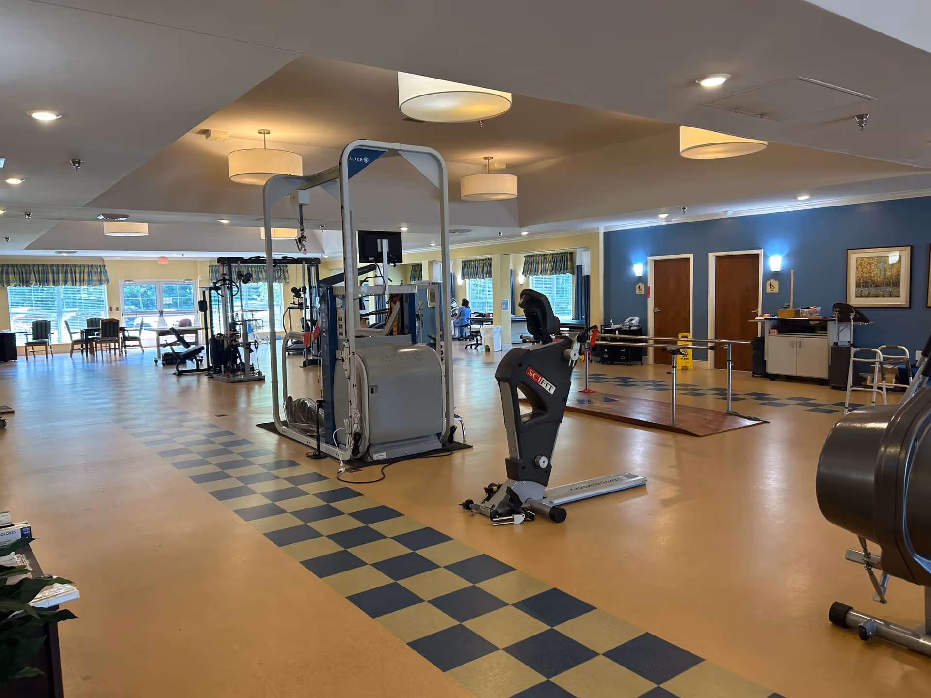Indoor senior fitness center with weight machines, cardio equipment, and open space.