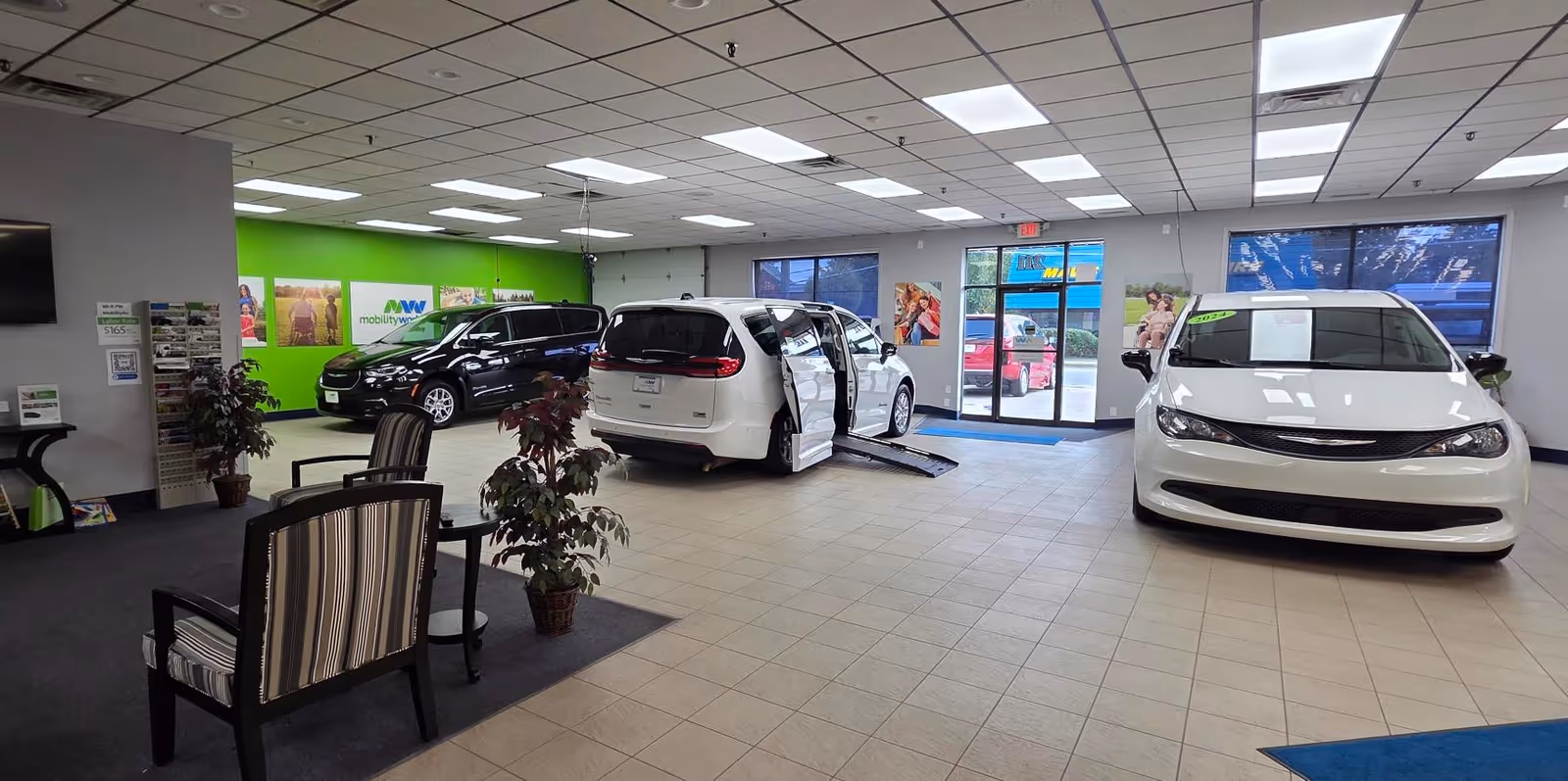 Interior showroom with multiple mobility vehicles on display and a seating area near the entrance.