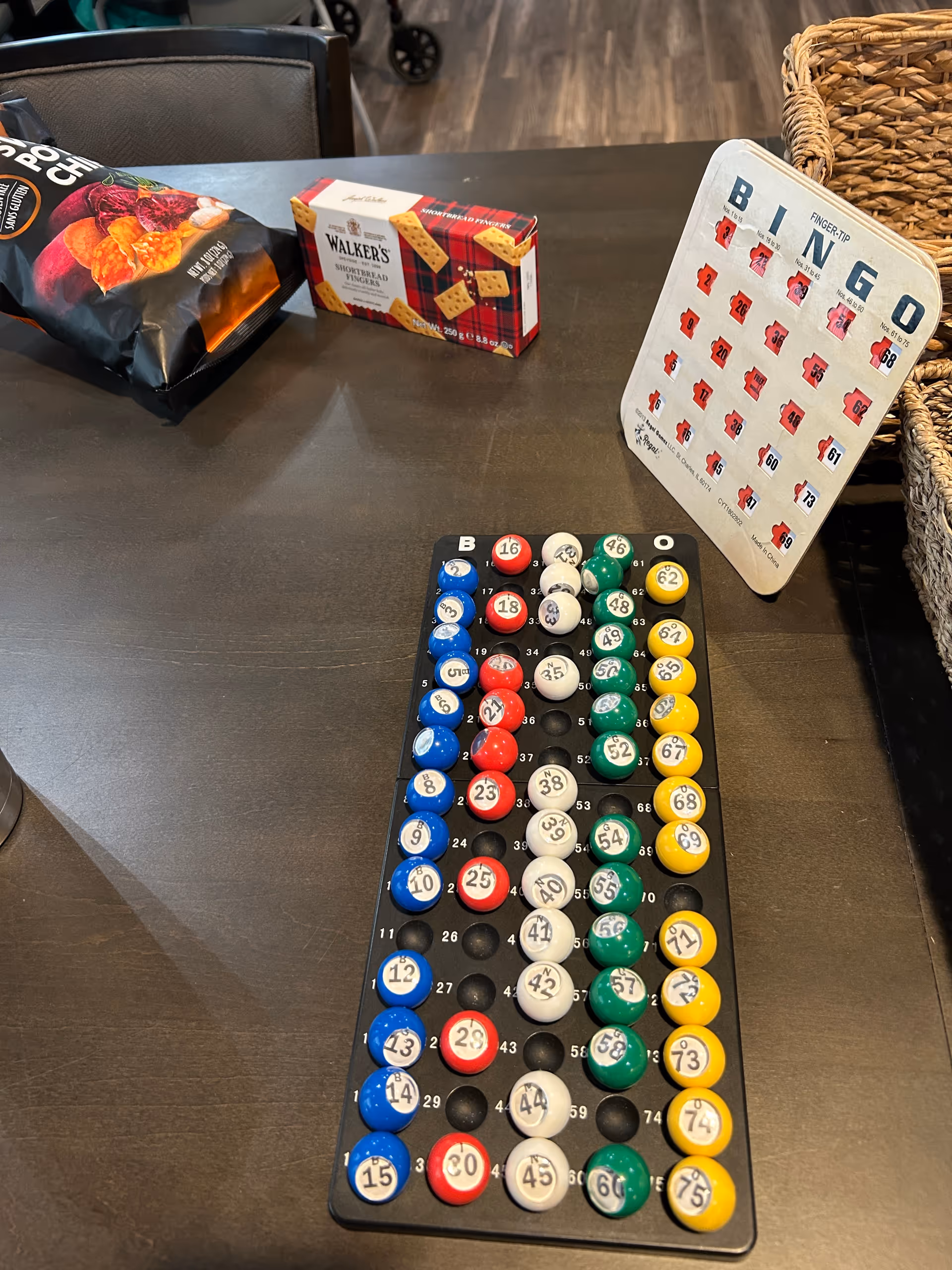 Bingo game board on a table with snack bags in a senior living facility.