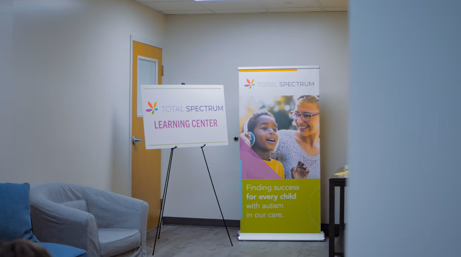 Indoor waiting area with Total Spectrum banners and a Learning Center sign.