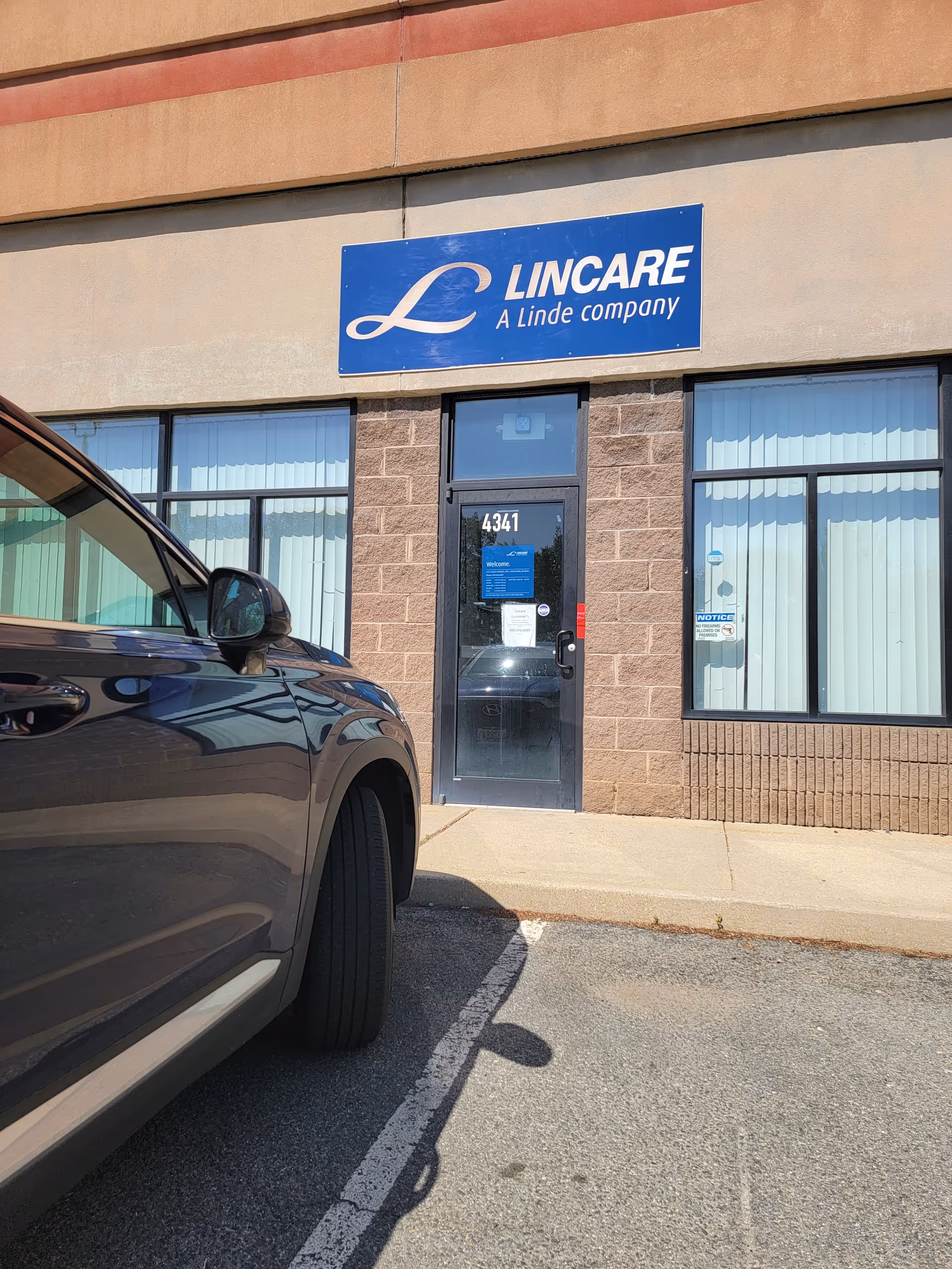 Exterior view of a LINCARE facility front with a parked car outside.