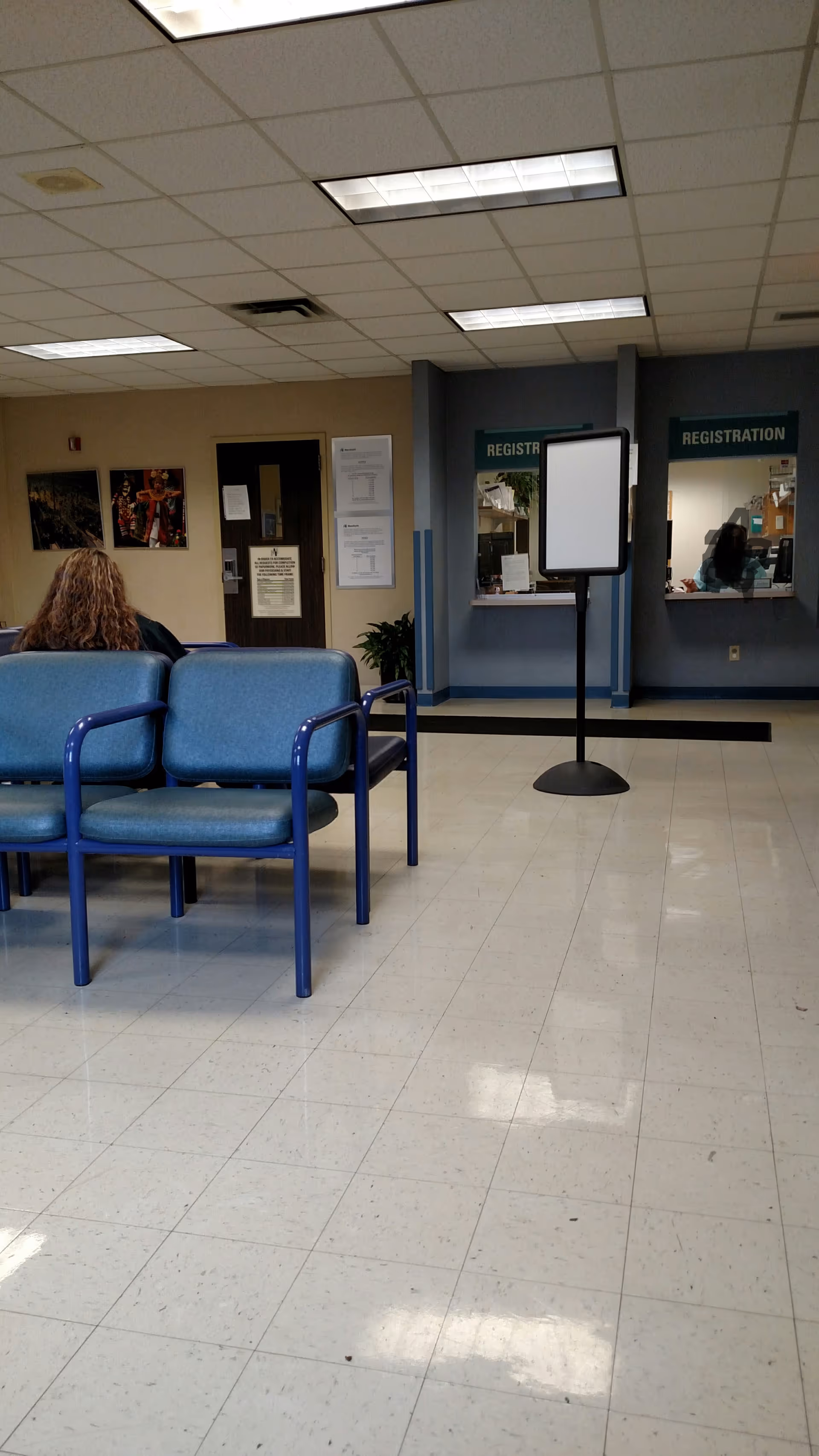 Lobby waiting area with blue chairs and a registration desk at Thomas F. McCafferty Health Center.
