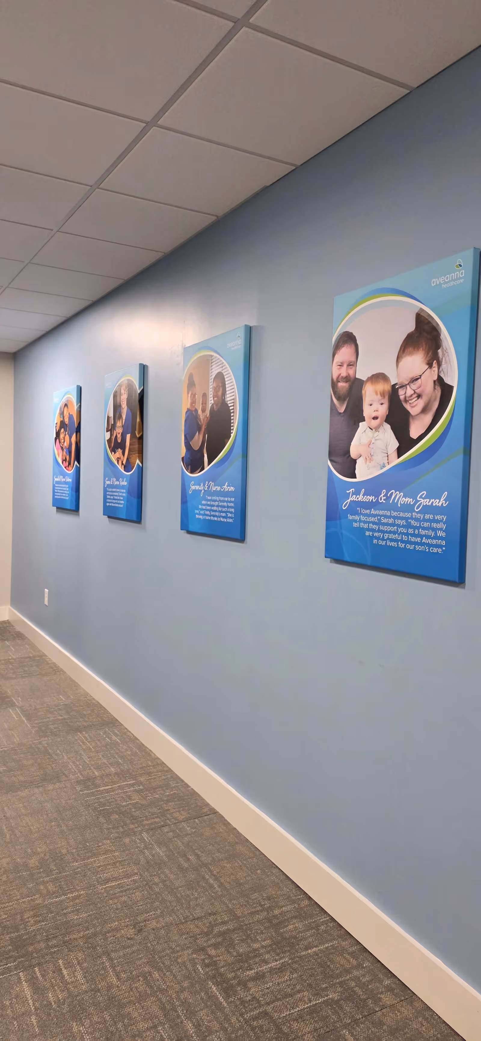 Blue-painted hallway with framed posters along a clean corridor.