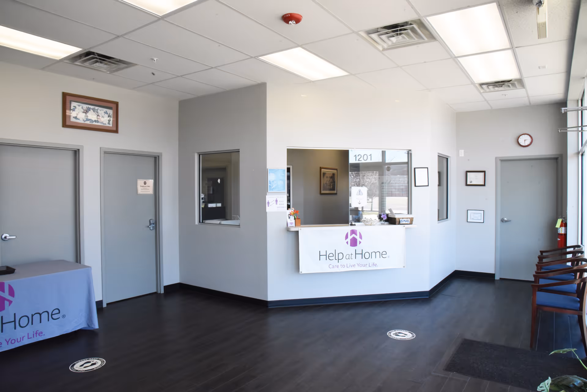 Lobby and reception area of Help at Home facility with front desk and chairs.