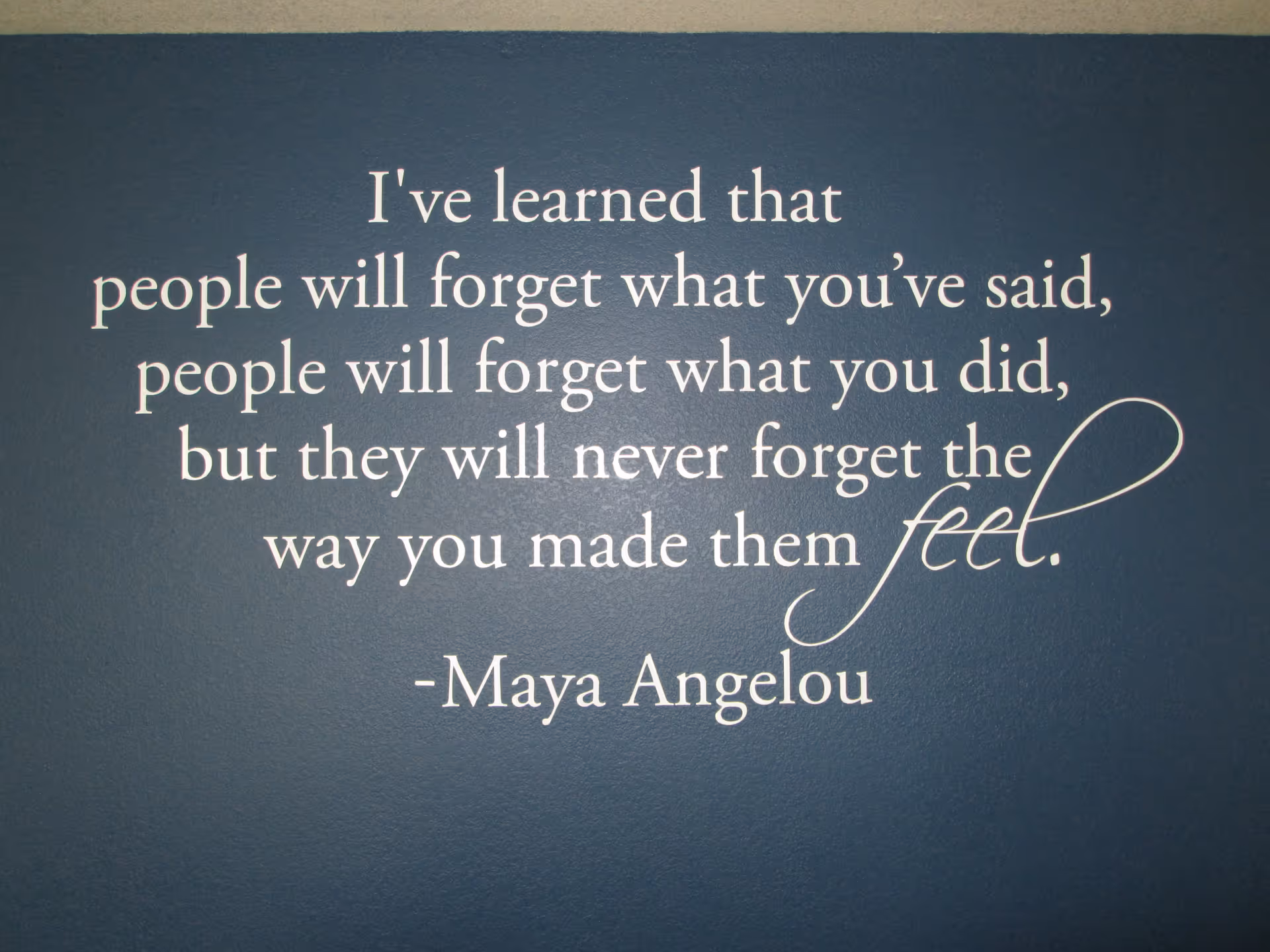 Blue interior wall with a white Maya Angelou quote about making people feel valued.