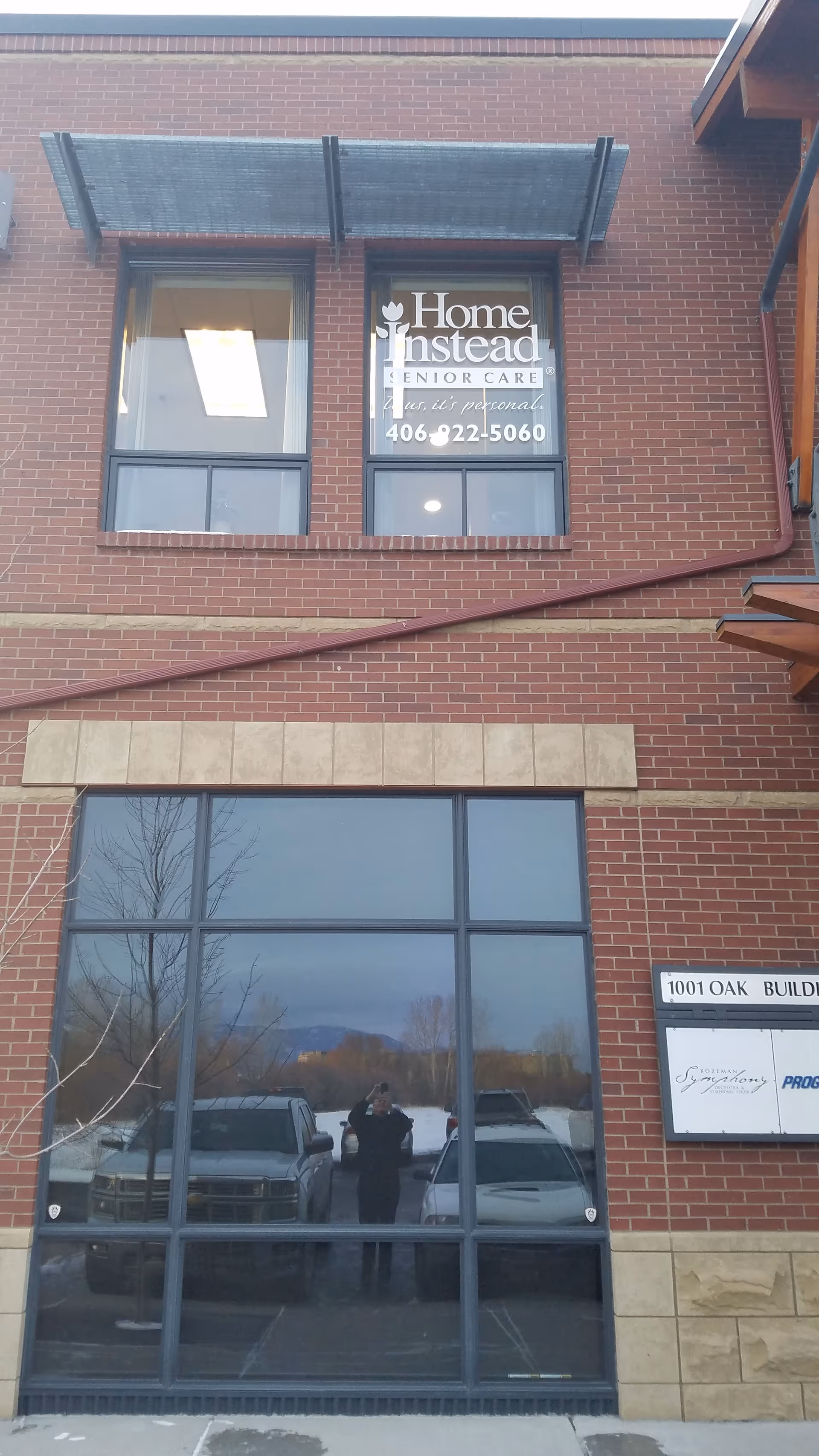 A brick building exterior with a Home Instead Senior Care sign in window.