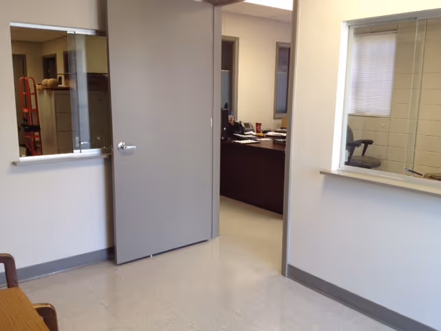 Interior hallway with an open doorway leading to a reception desk area in a facility.
