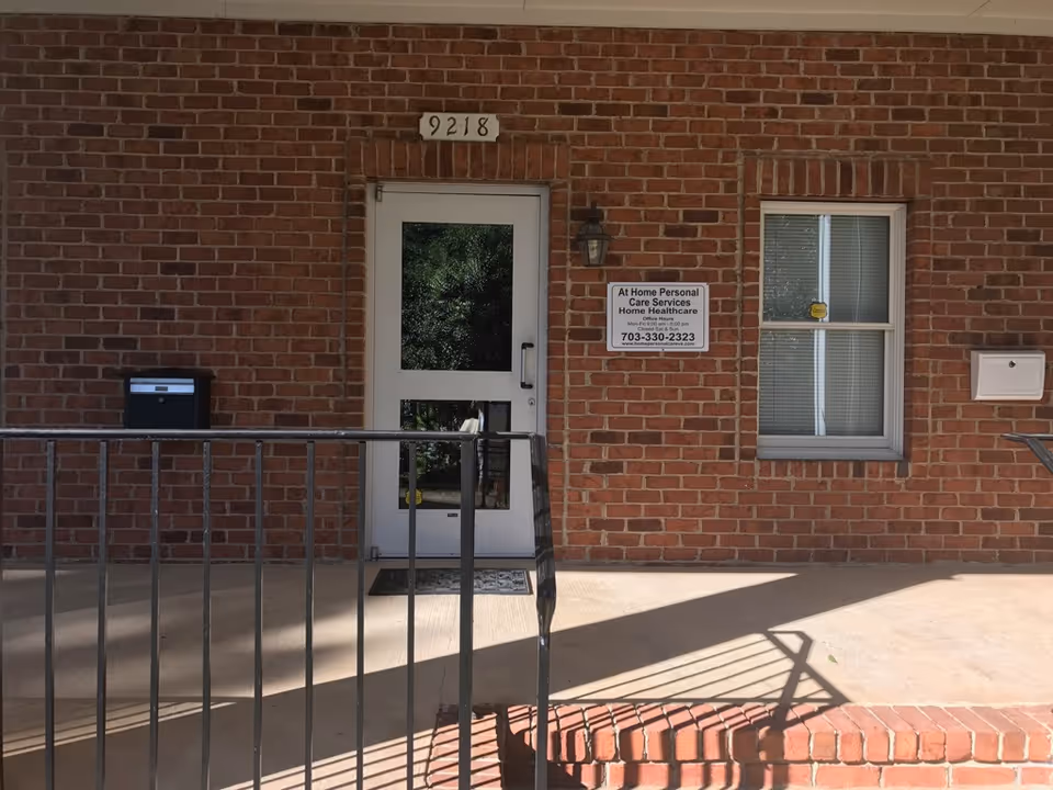 Brick building entrance with white door, window, and facility sign.