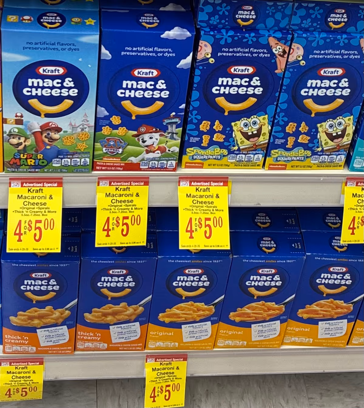 Rows of Kraft Mac & Cheese boxes on store shelves with yellow sale signs.