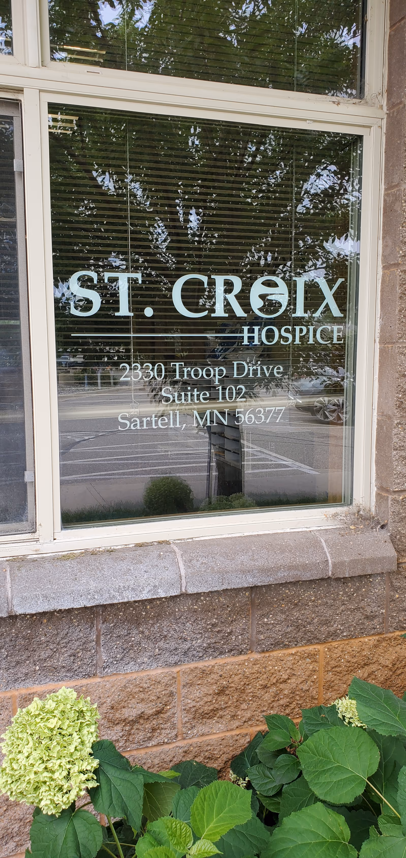Front window displays St. Croix Hospice signage and address on an exterior wall.