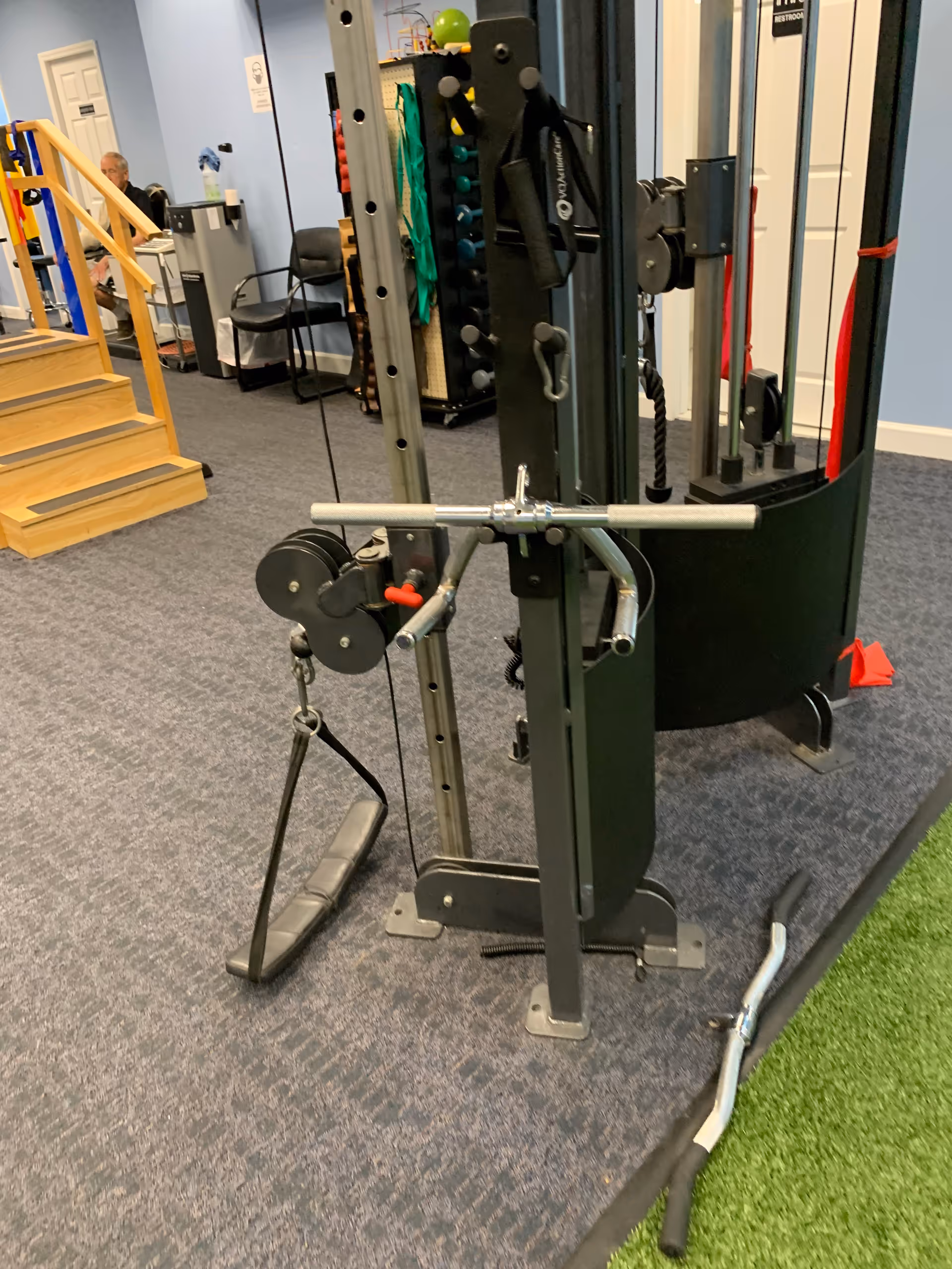 Interior gym area with weight machines, cables, and exercise equipment.