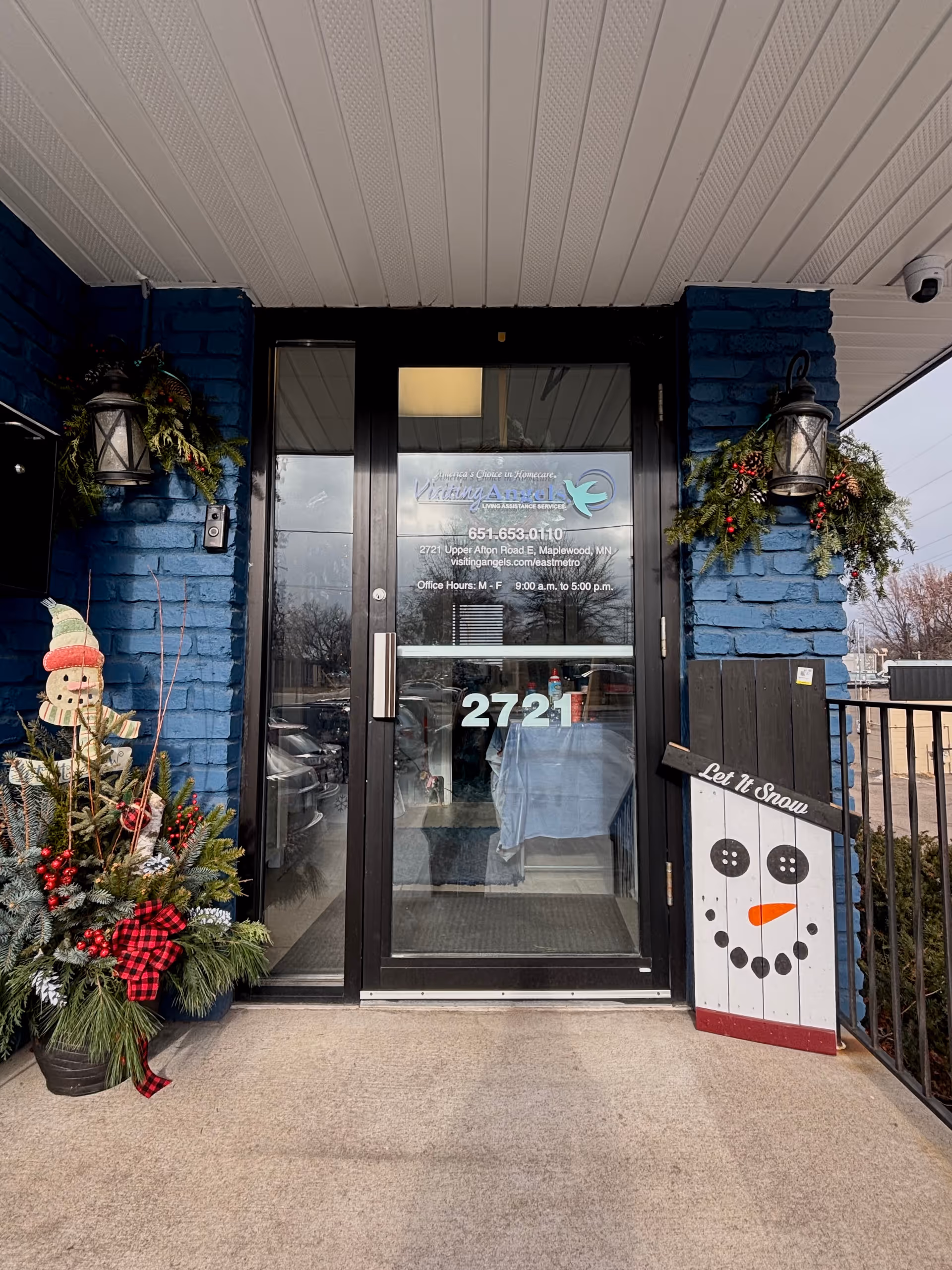 Blue brick entrance of Visiting Angels Senior Home Care with holiday decorations and glass doors, 2721