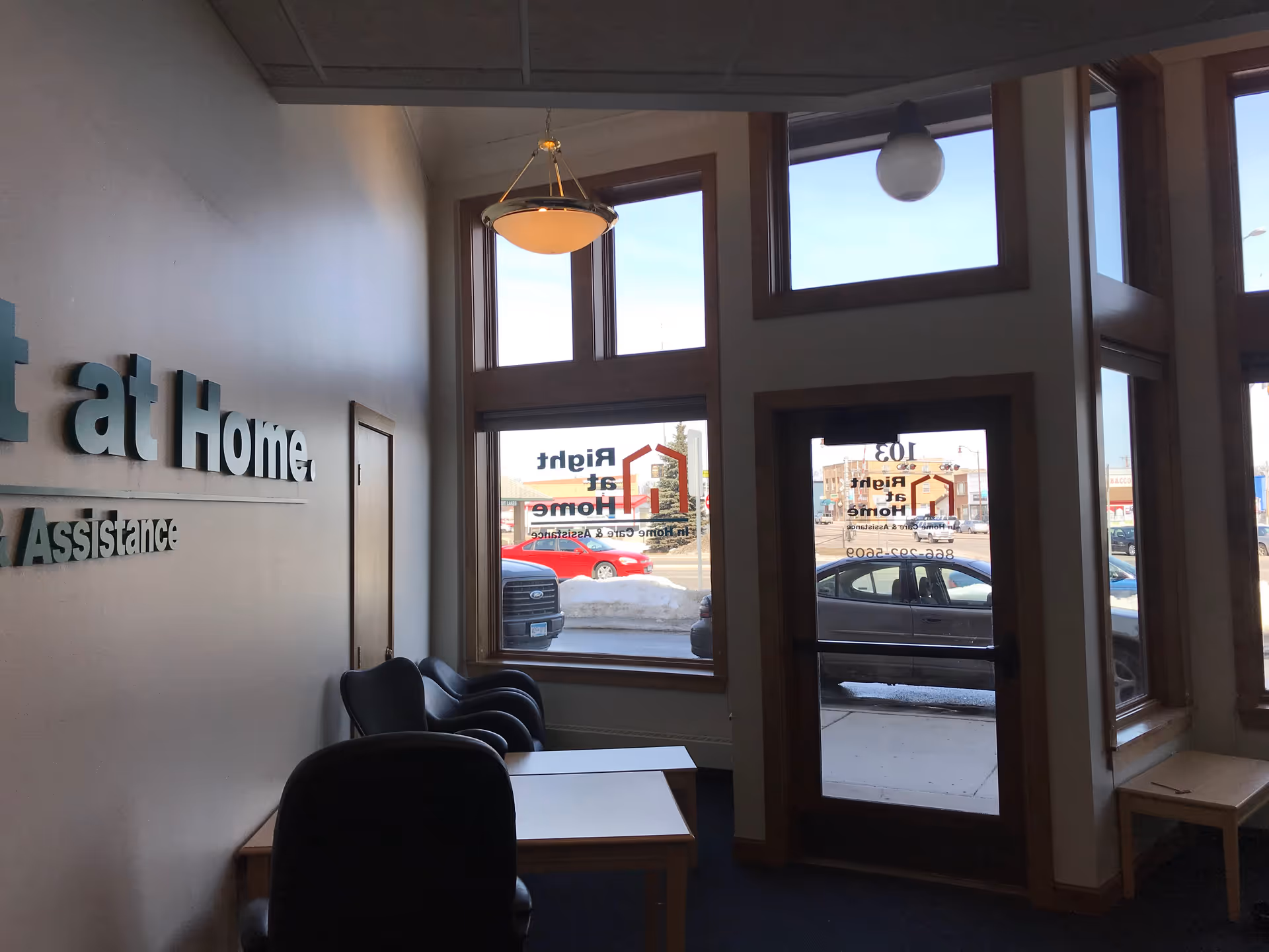 Interior lobby area with seating, tables, and large windows at Right at Home facility.