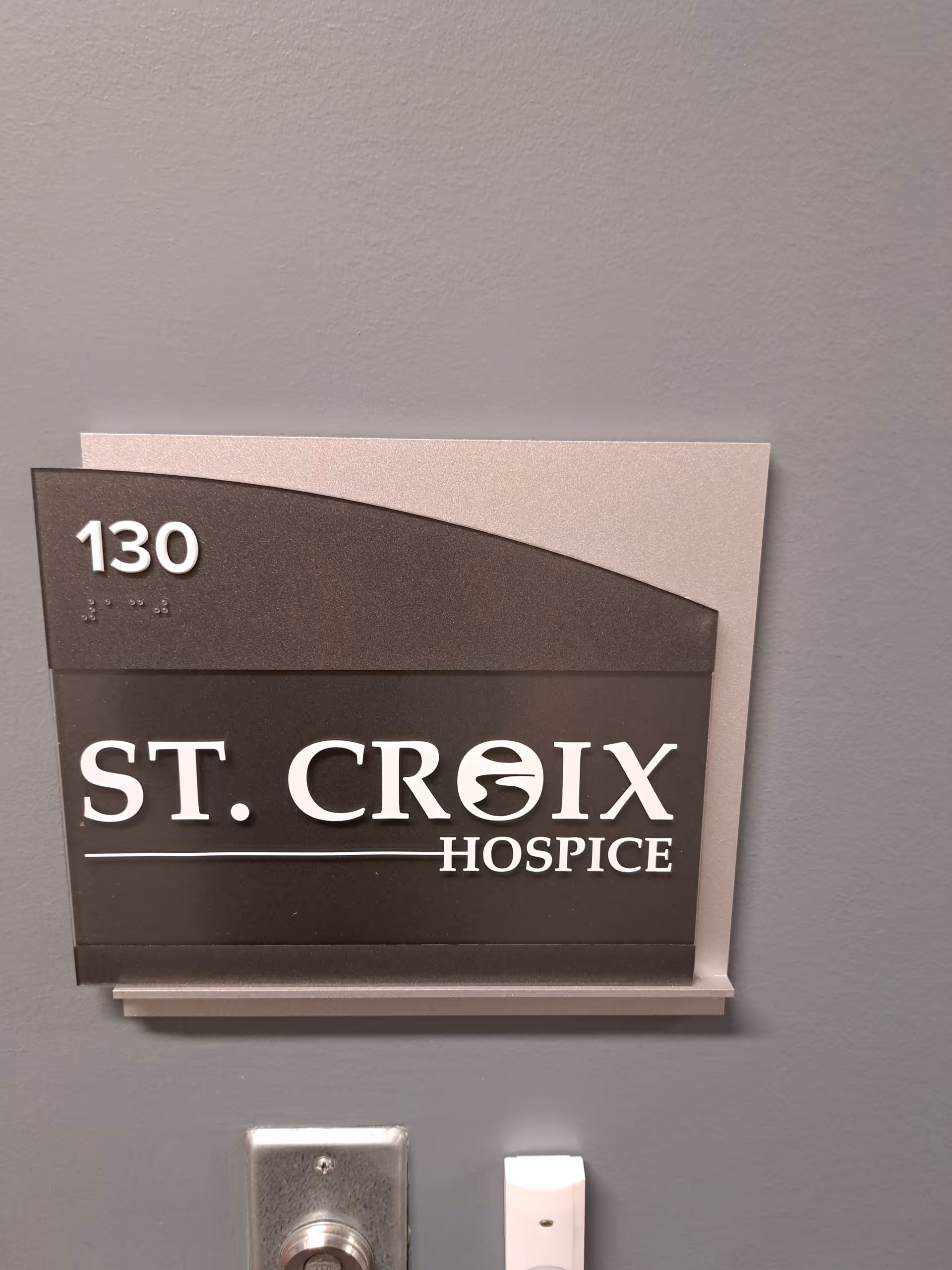 Interior hallway sign reading ST. CROIX HOSPICE and the number 130 on the wall