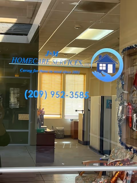 Glass storefront door displaying J&M Homecare Services; lobby interior with chairs and blinds visible.