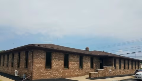 Brick exterior of Comfort Keepers senior living building with windows and a parking lot.
