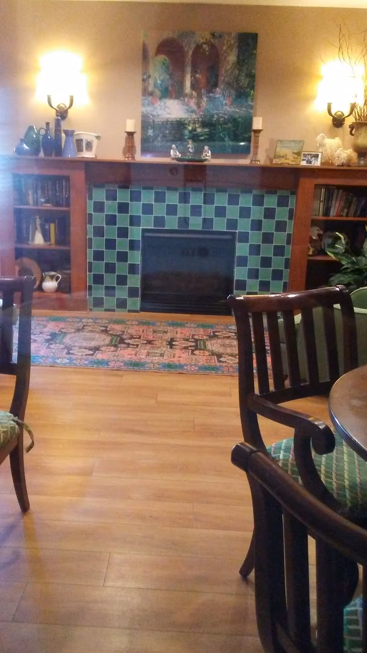 A cozy living room with a tiled fireplace, built-in shelves, and seating.