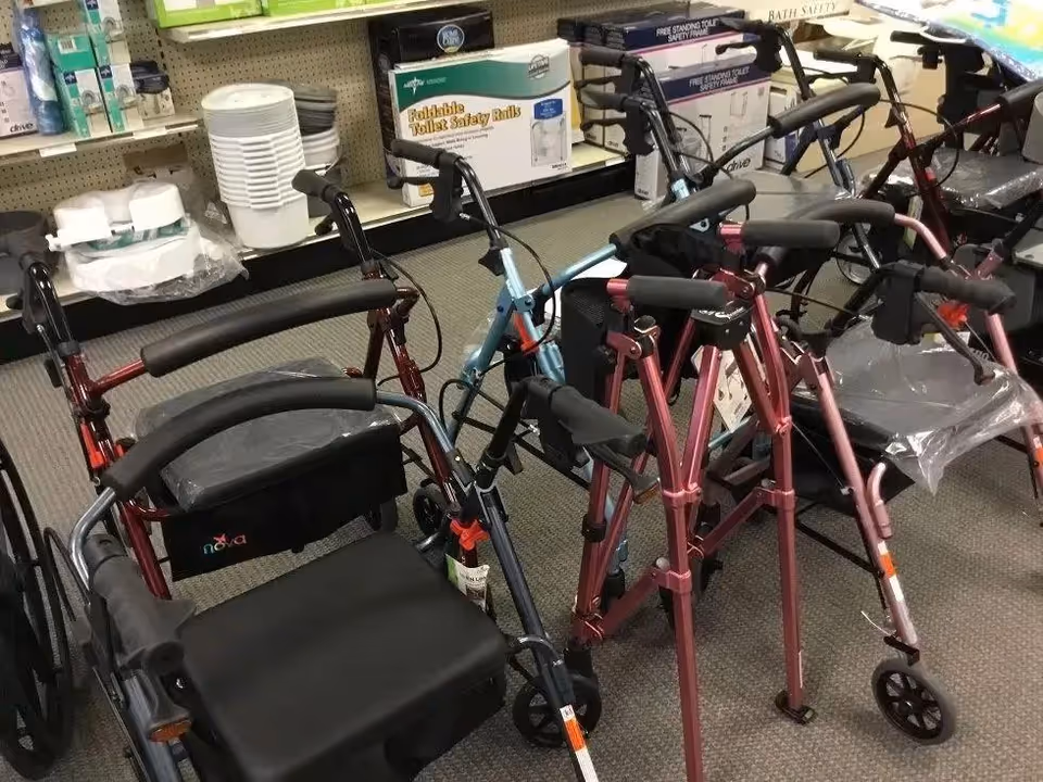 Indoor store display of walkers and mobility aids in assorted colors.