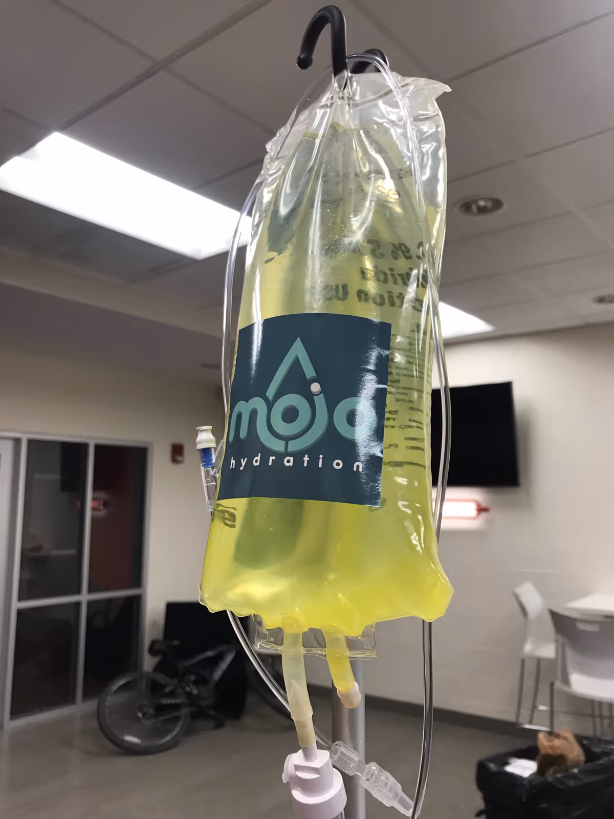 IV bag labeled Mojo Hydration hangs from a pole in a clinical room