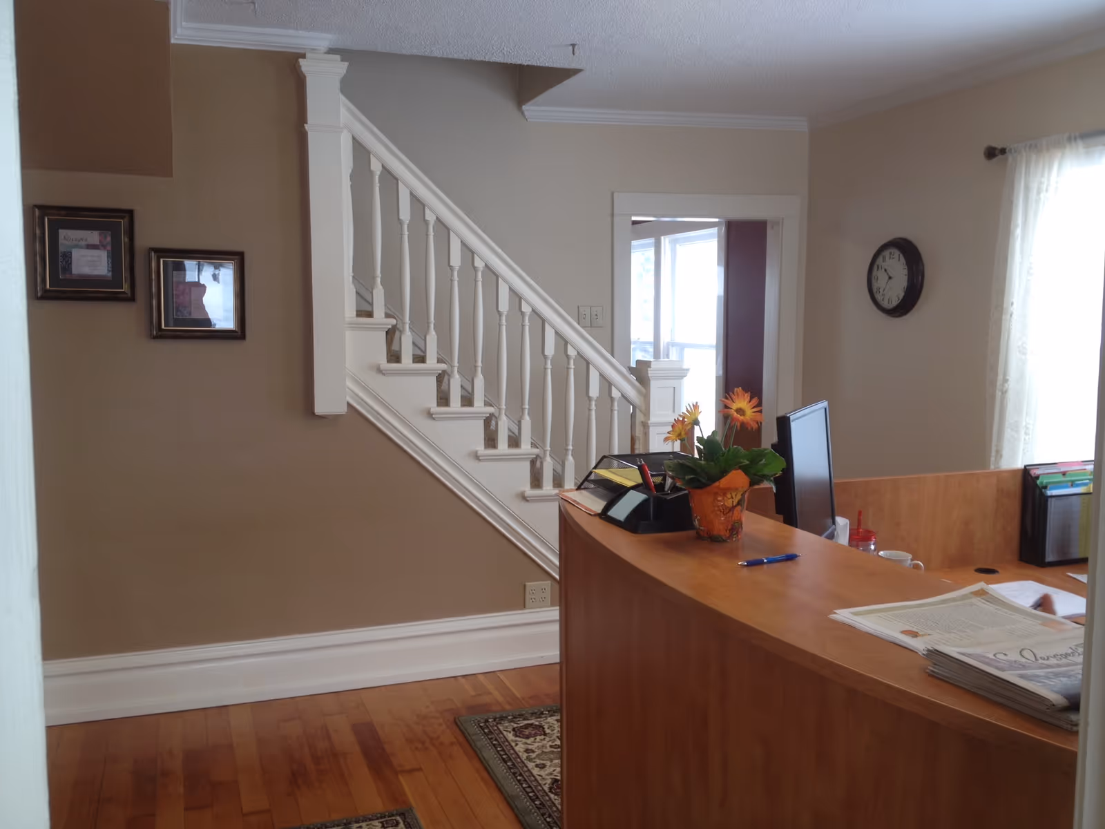 Reception desk with flowers and a computer in a hallway at Alternative Senior Care.