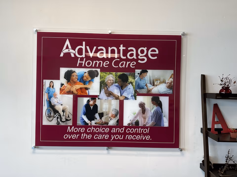 Maroon Advantage Home Care sign with a collage of caregiving photos mounted on a wall.