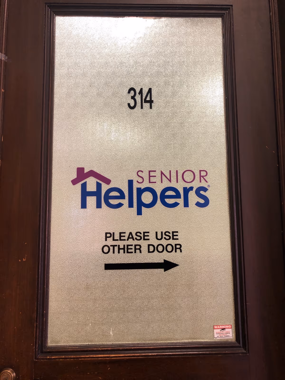 Door with number 314 and Senior Helpers branding, directing to use the other door.