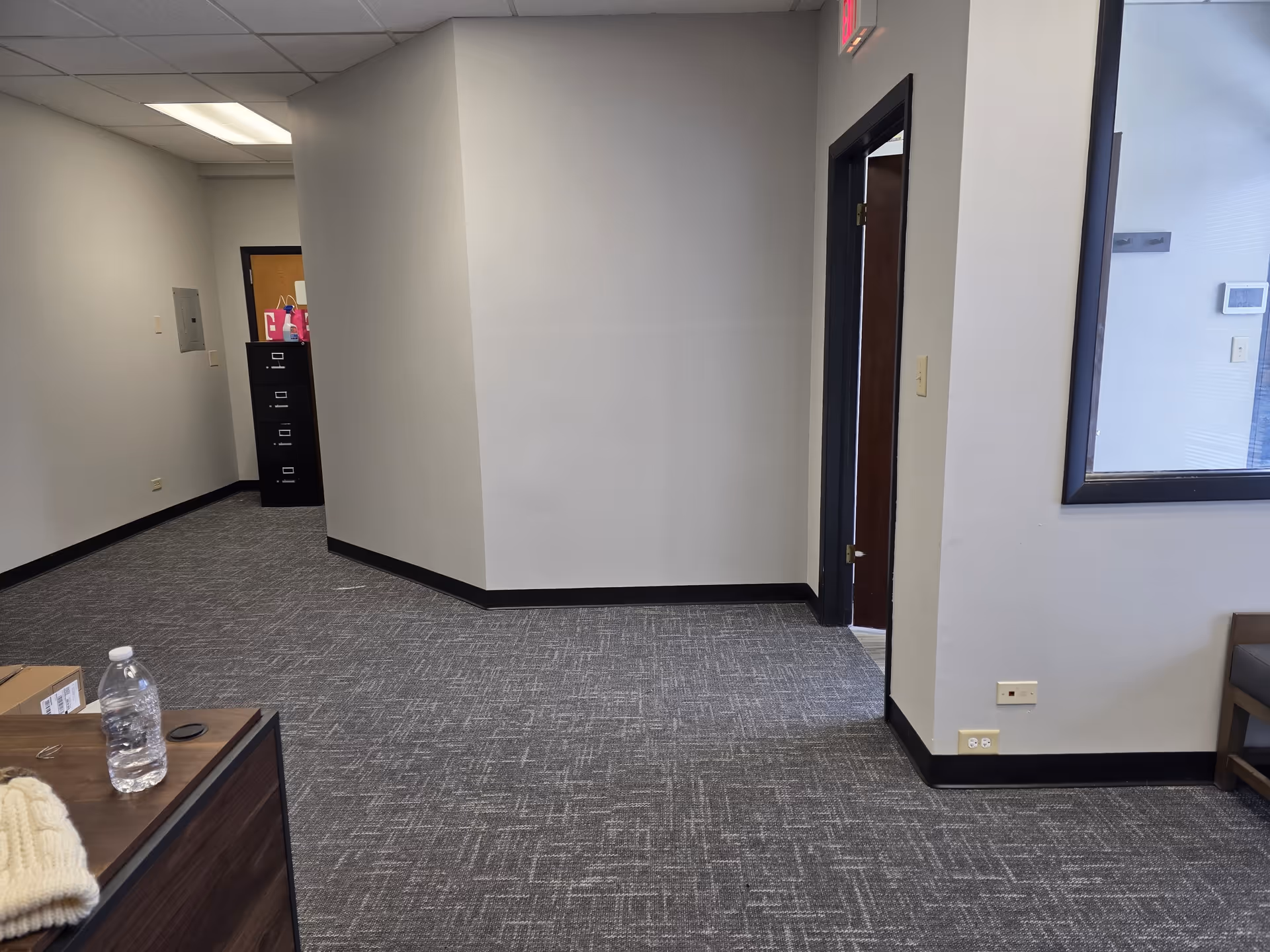 Interior hallway of Unity Home Care Services facility with carpet, walls, doors, and a window