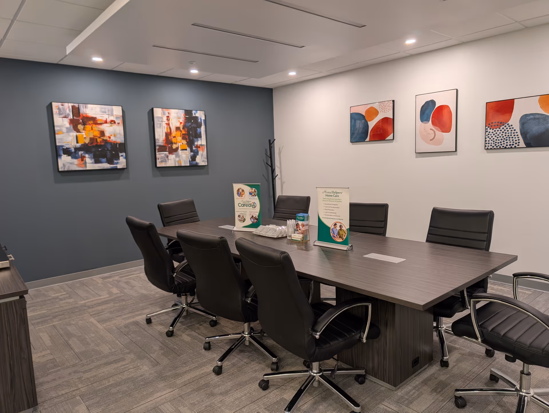 Modern conference room in a senior care facility with a long table and abstract art.