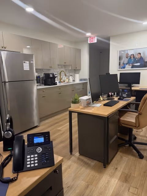 Kitchenette and desks with computers in a River Oaks Home Care office.