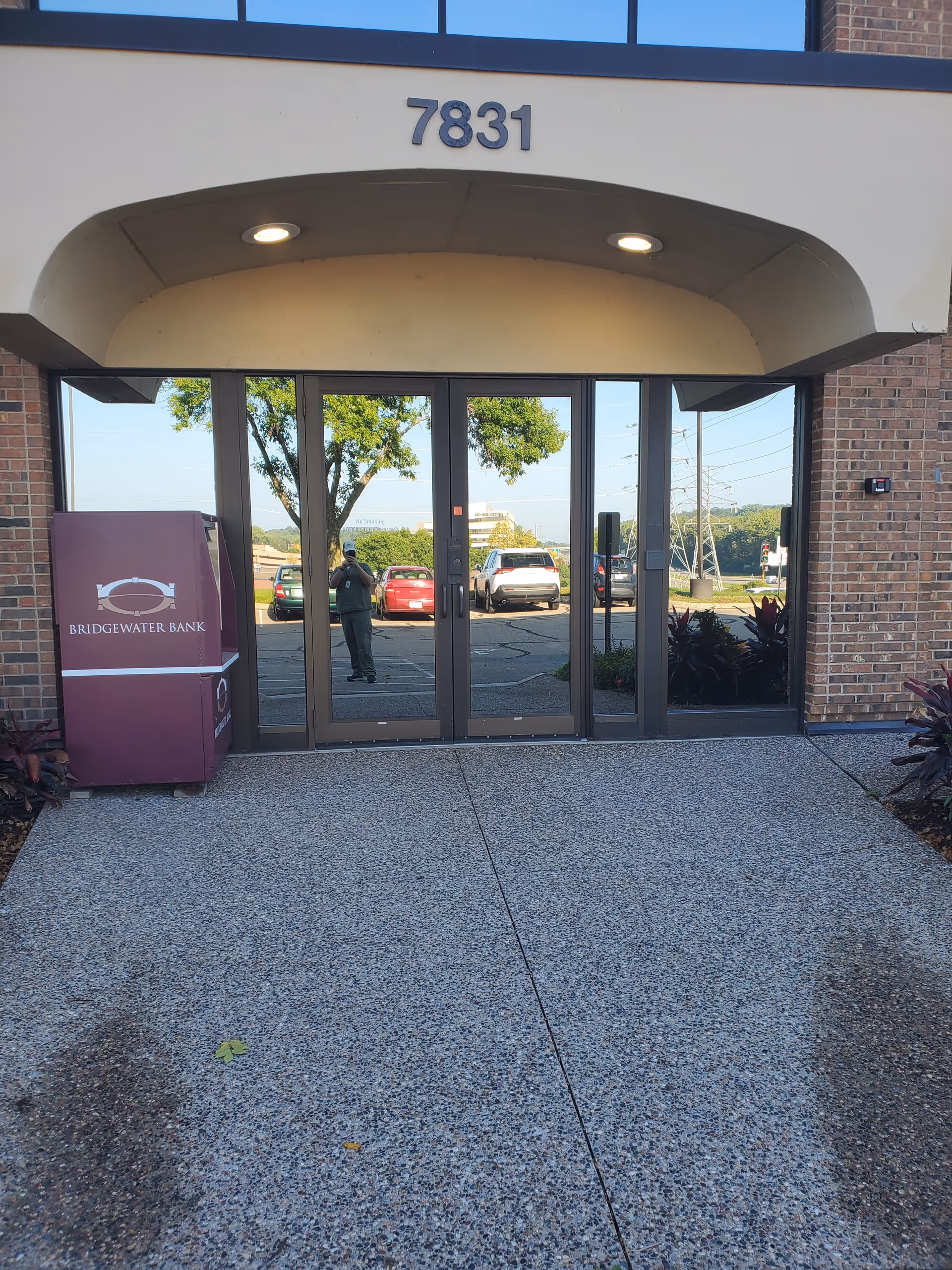 Front entrance of a brick building with glass doors and 7831.