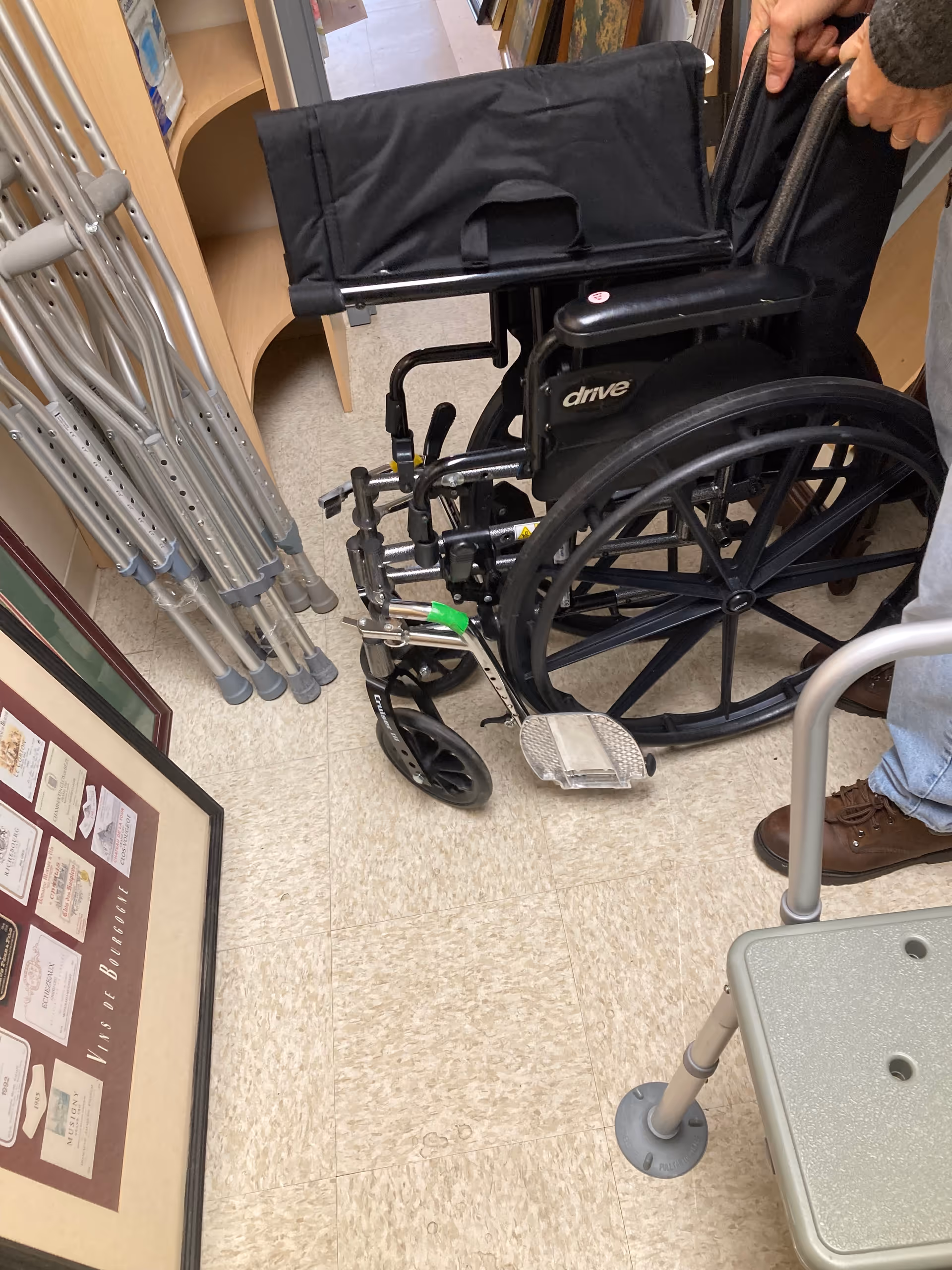 Interior hallway with wheelchair, crutches, and a walker near a display board.