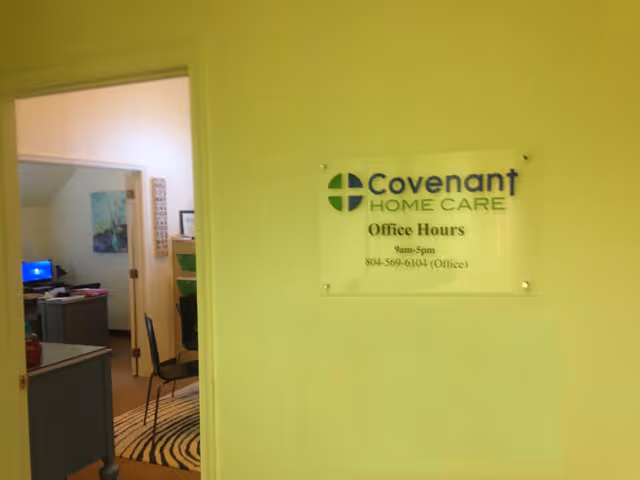 Yellow-walled hallway with a Covenant Home Care sign and adjacent office area.