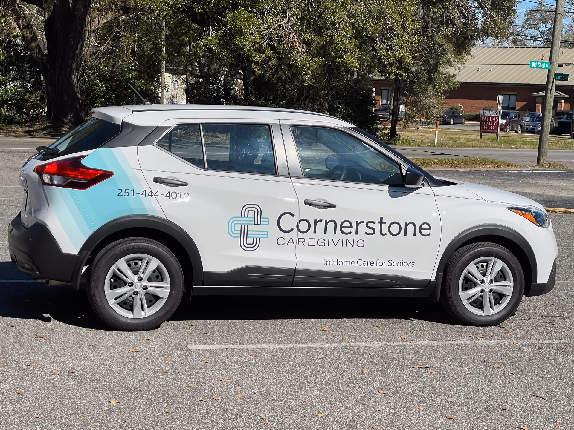 White Cornerstone Caregiving SUV with logo parked on a street.