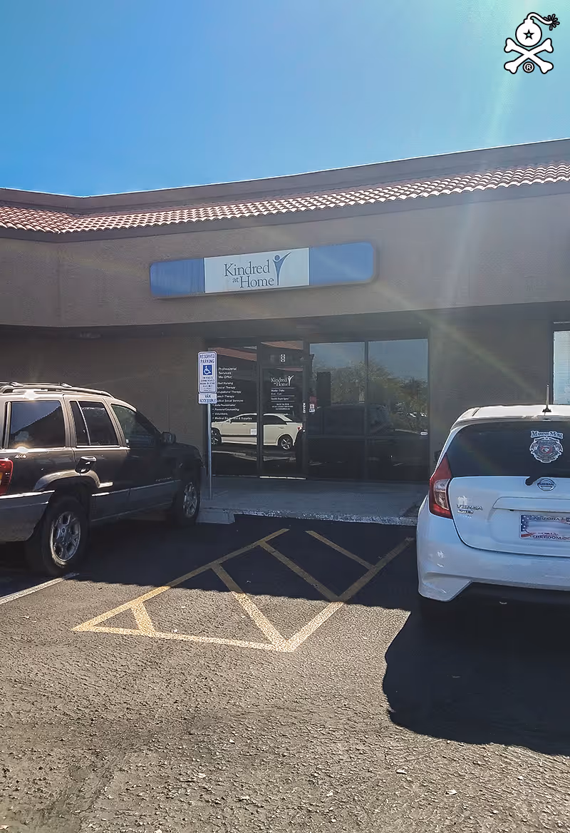 Front exterior of a Kindred at Home facility with parked cars.