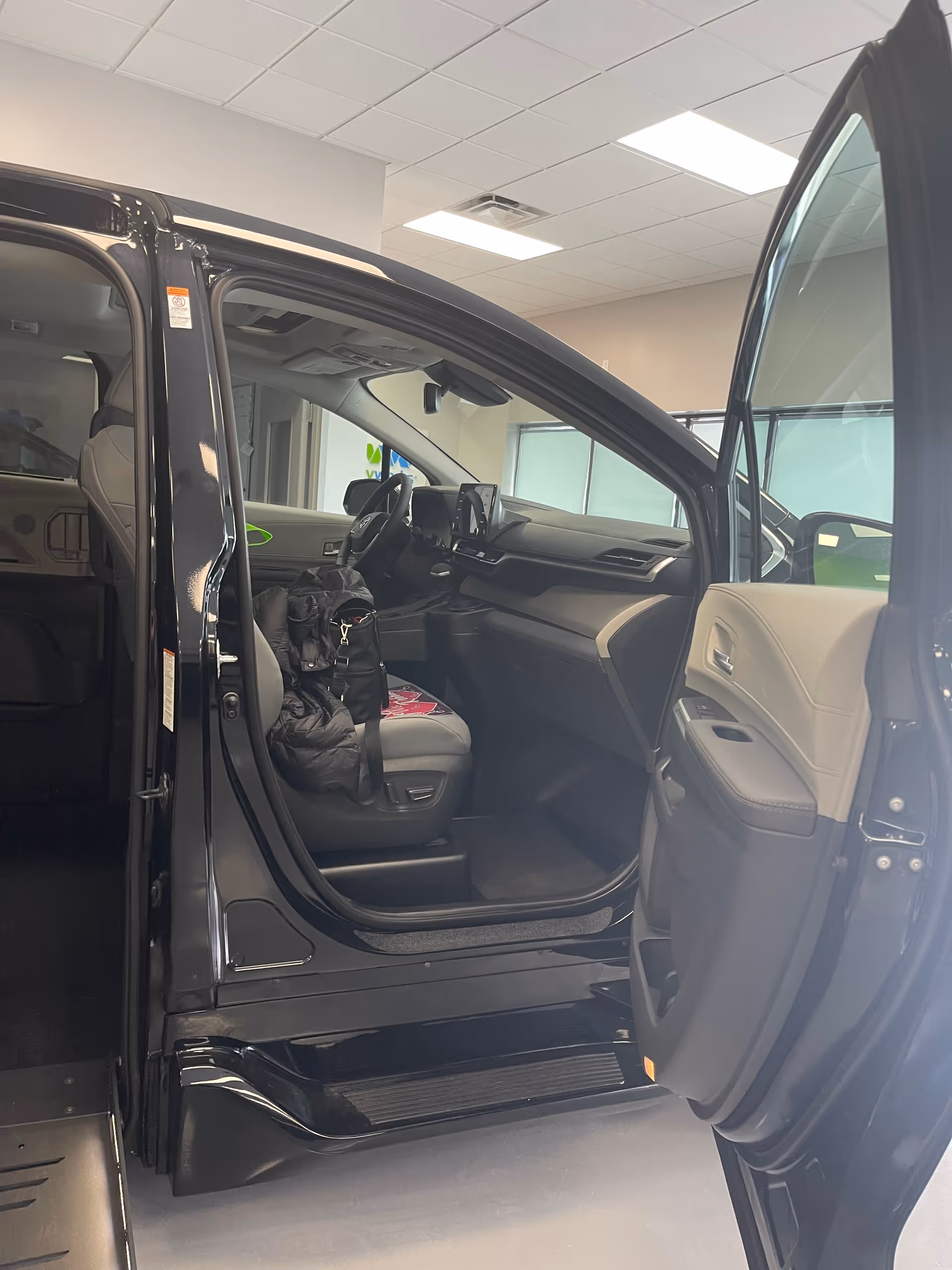 Open passenger door shows black SUV cabin with front seat and dashboard