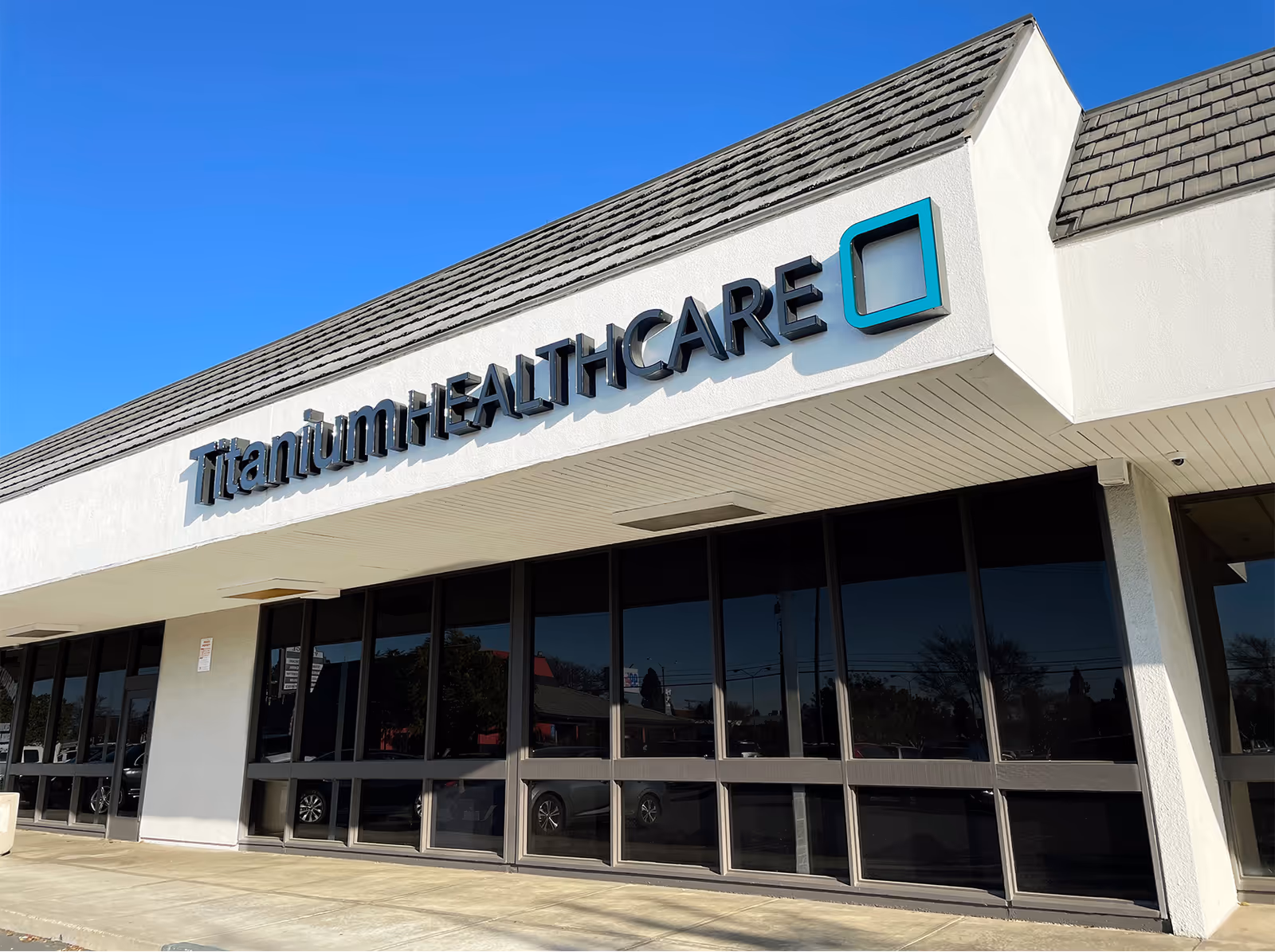 Exterior view of Titanium Healthcare building with signage and glass storefront.