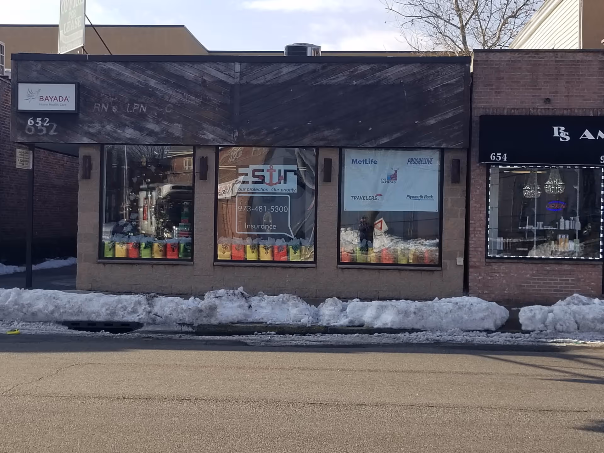 Exterior storefronts along a snowy street; Bayada Assistive Care sign visible.