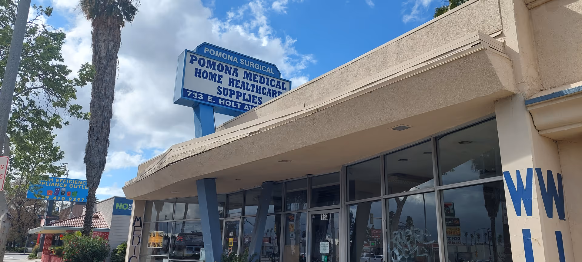 Exterior storefront of Pomona Medical Supply with blue sign and large glass windows.