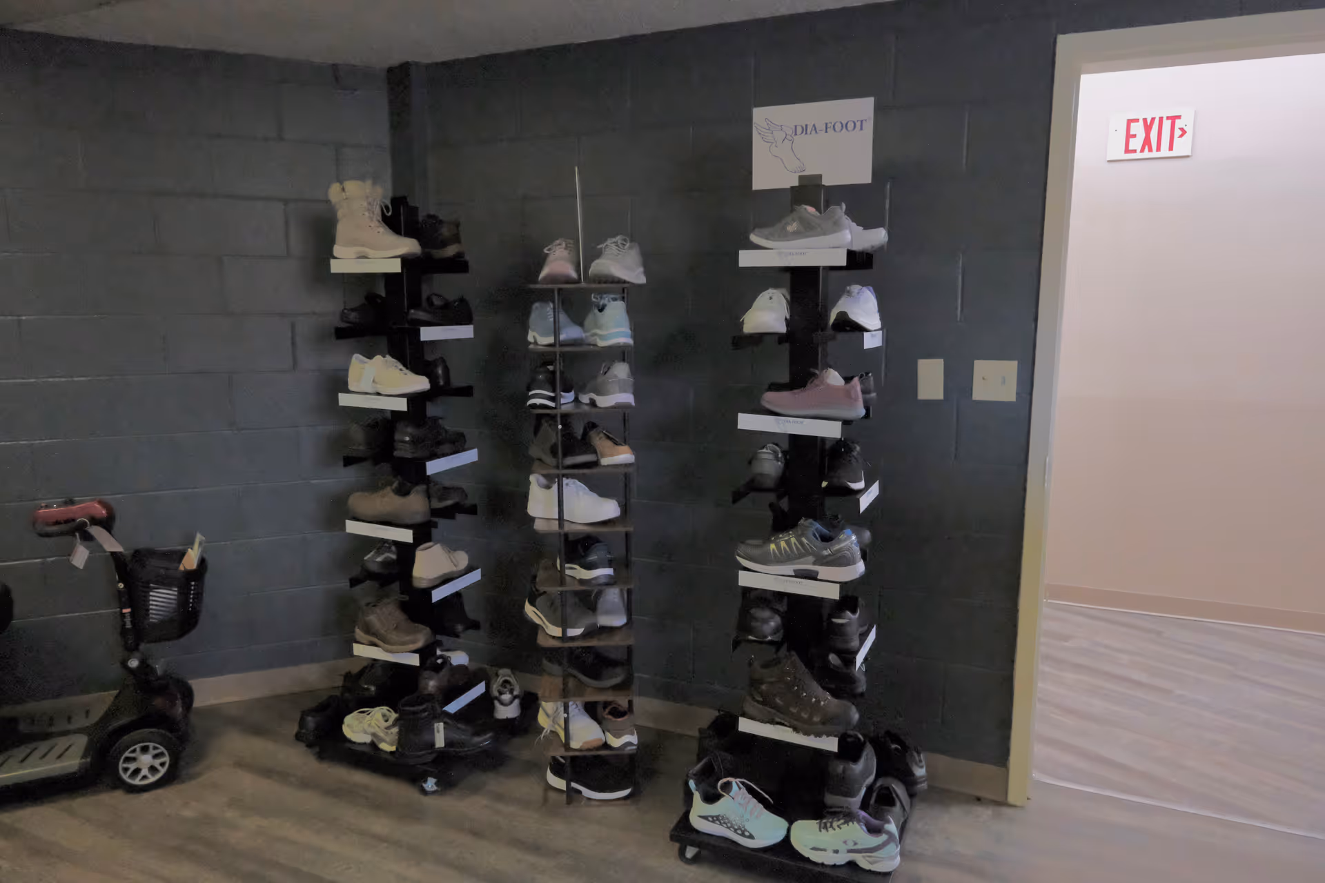 Interior hallway with multi-tier shoe racks and a small scooter nearby.