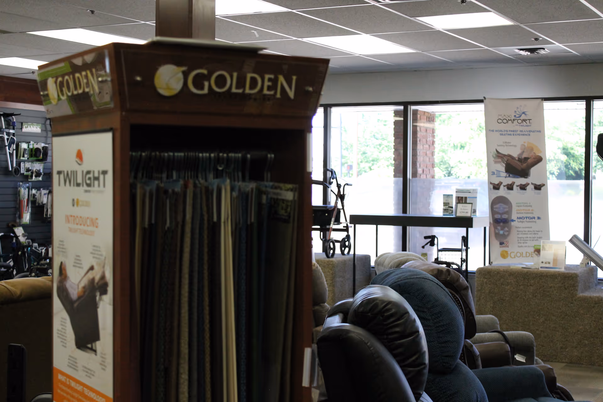 Indoor showroom with a clothing rack, chairs, and banners in a senior facility.