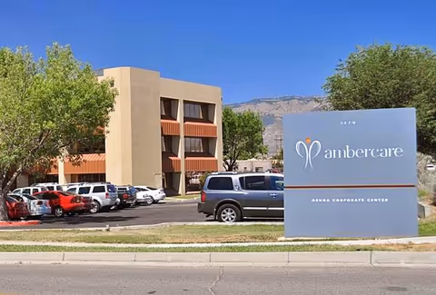 Exterior view of Ambercare facility with a large sign and parked cars